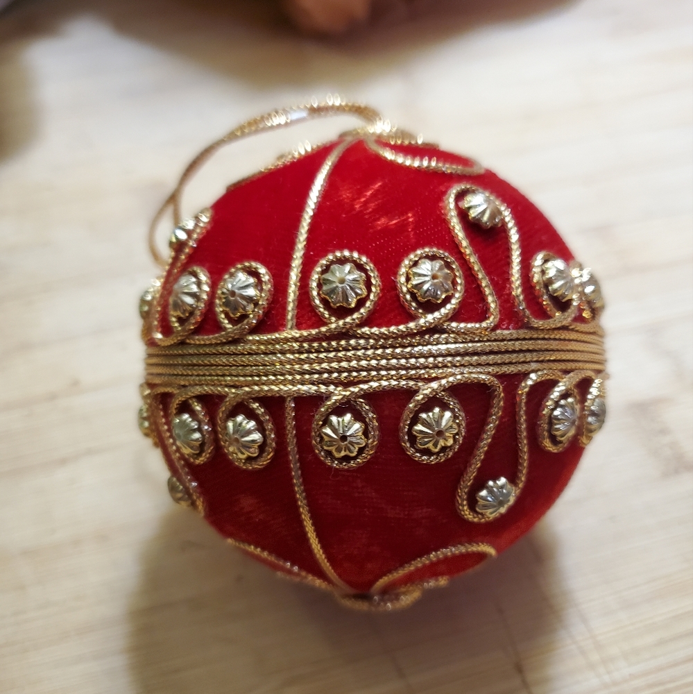 Red beaded holiday ornament with gold corded trim